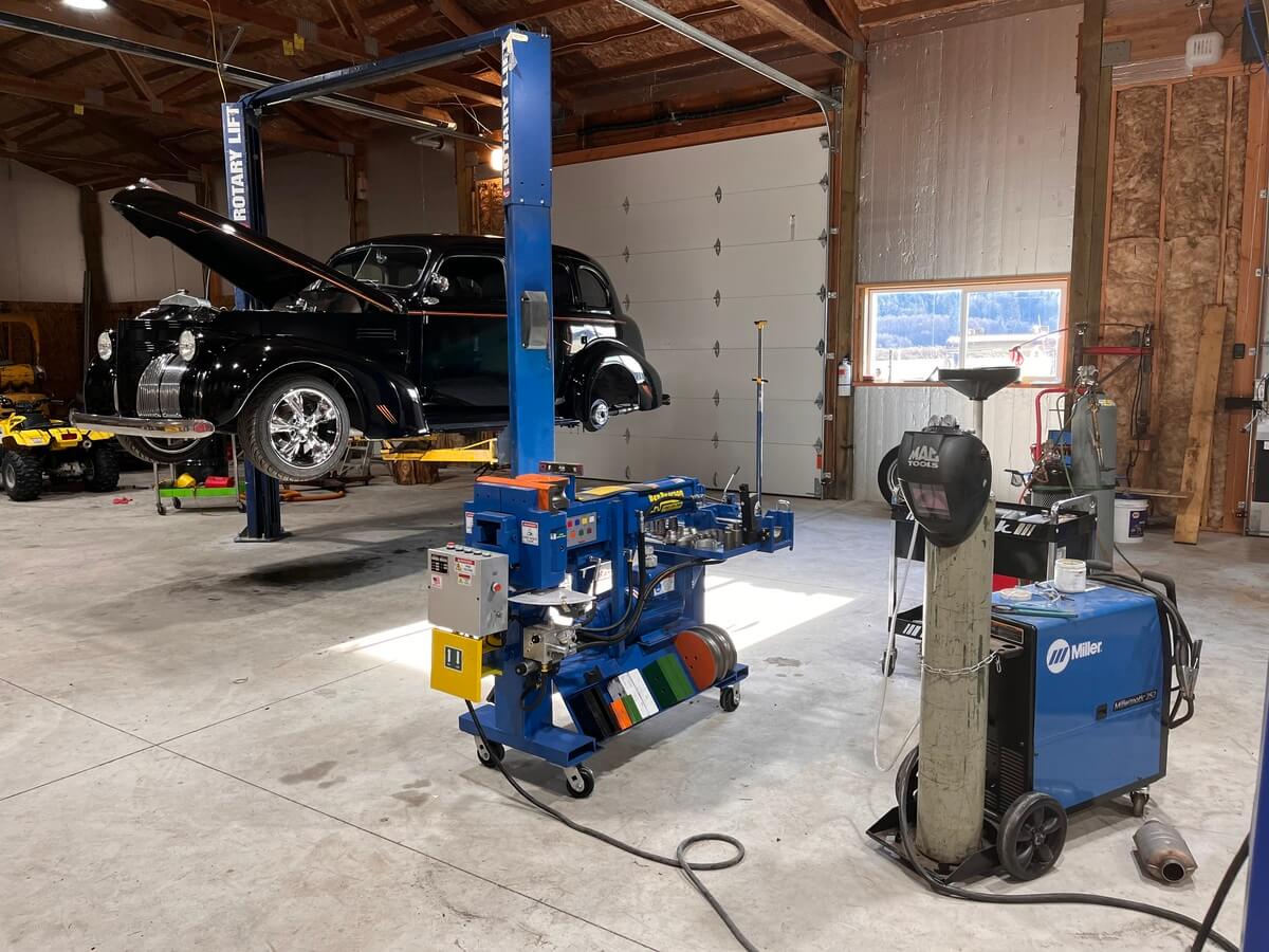 A black truck is sitting on a lift in a garage.