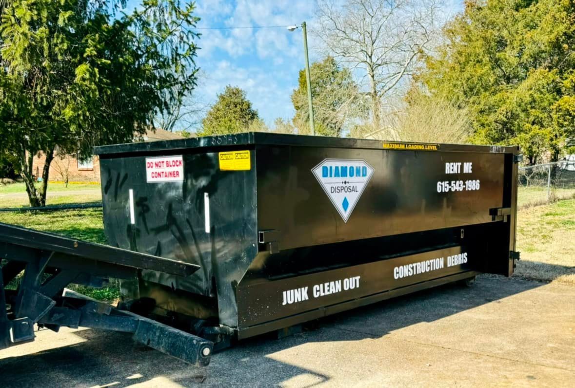 A black dumpster trailer marked with 