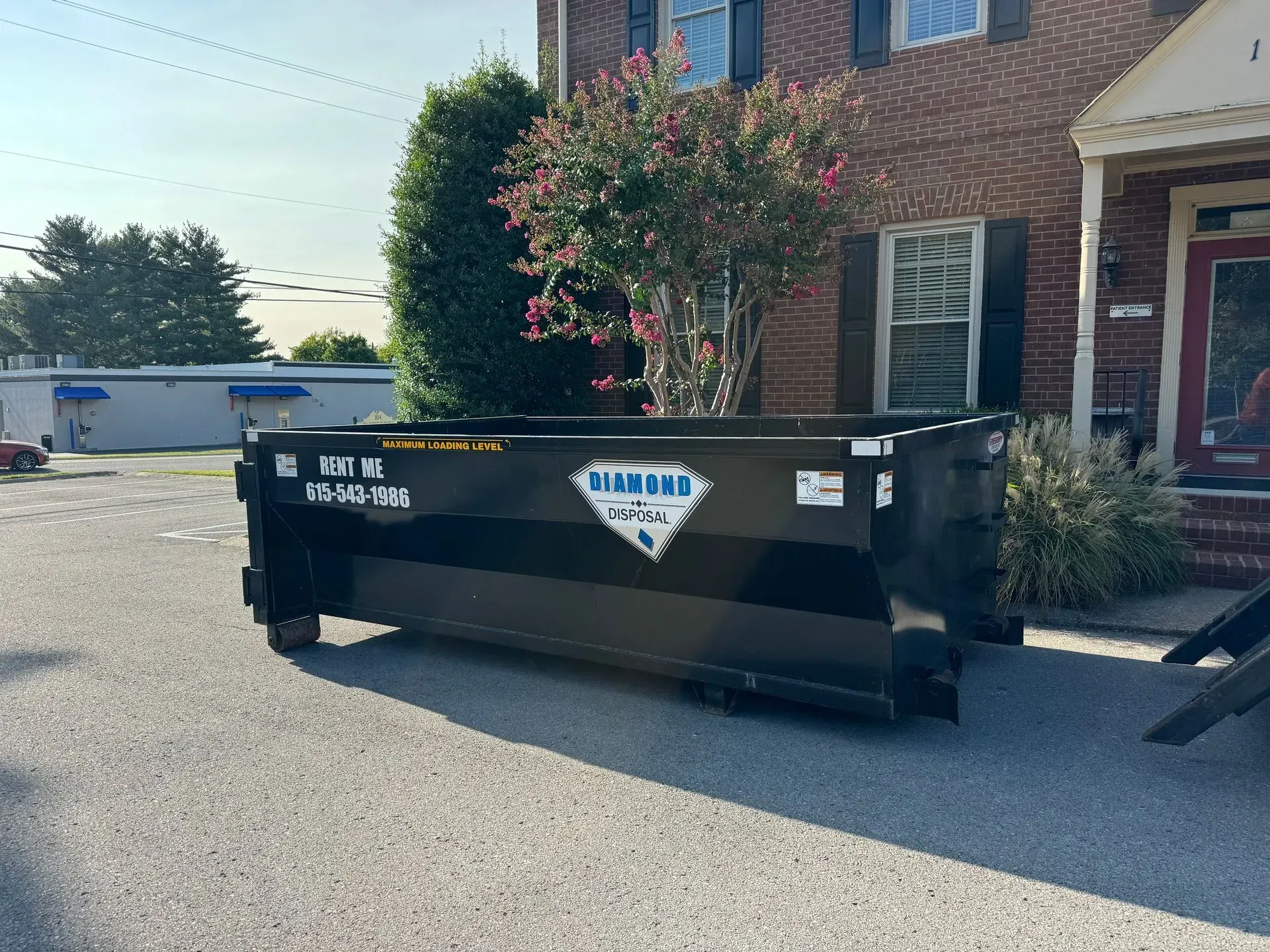A black dumpster labeled 