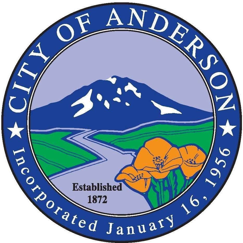 Official seal of Anderson with a mountain landscape, river, green fields, poppies, and dates 1872 and 1956.