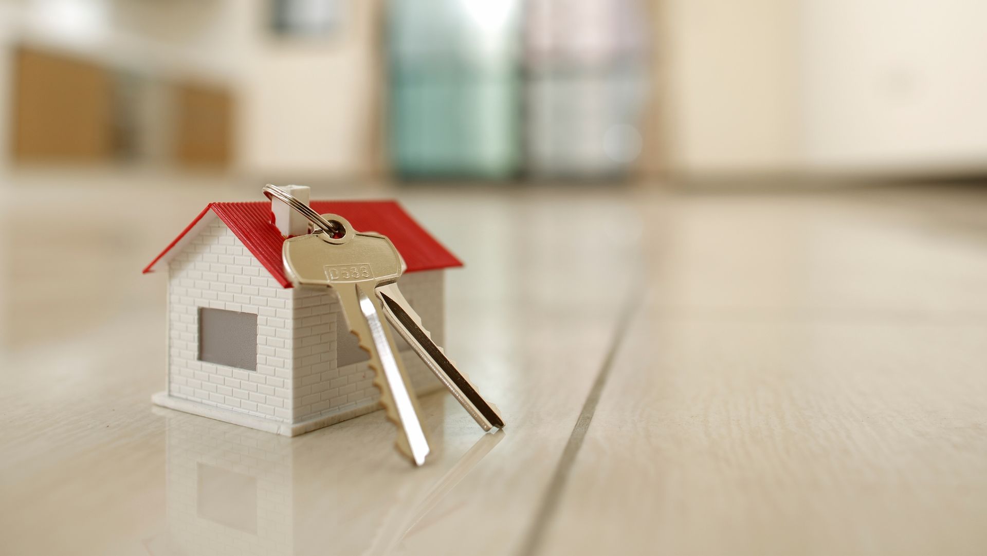 Mini house with keys symbolizing real estate ownership