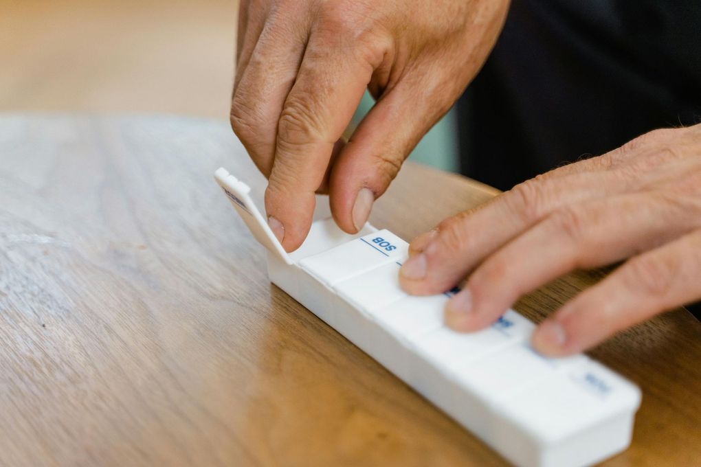 Hands pressing buttons on a white electronic device on a wooden table
