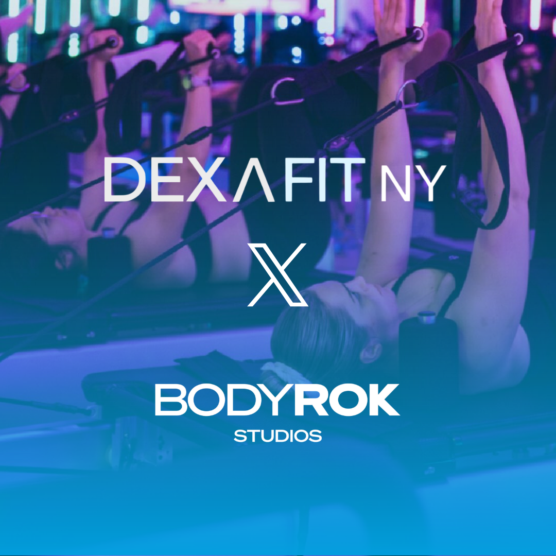 People lifting weights in a gym; Iron Oasis X DexaFit NY logo. Red weights and blue floor.