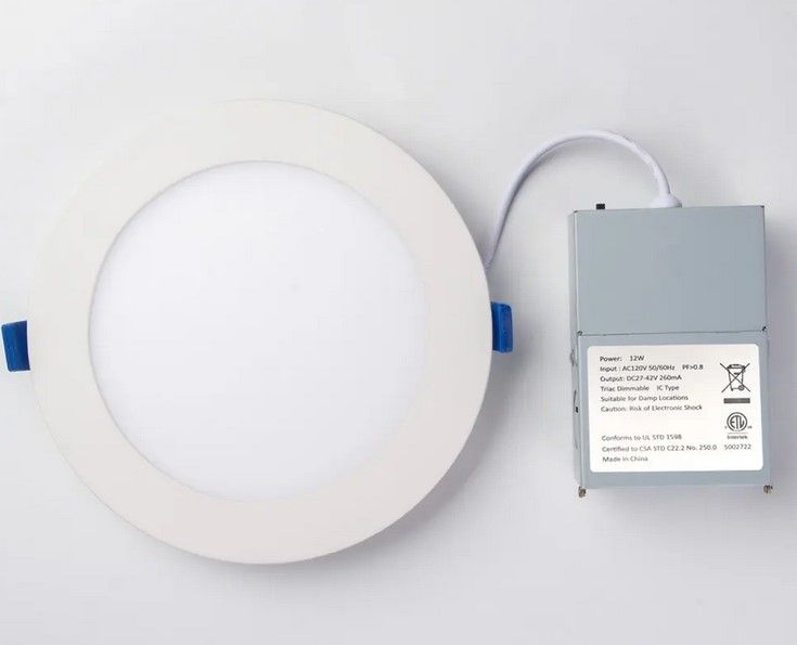 Round LED recessed light fixture with a white rim and a connected power supply.