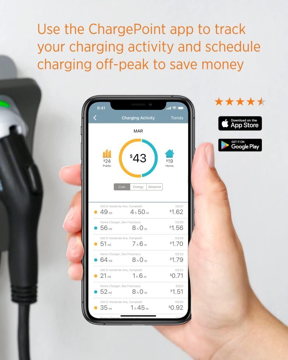 A person plugs an electric vehicle charger into a wall-mounted charging station. The charger is black and green.