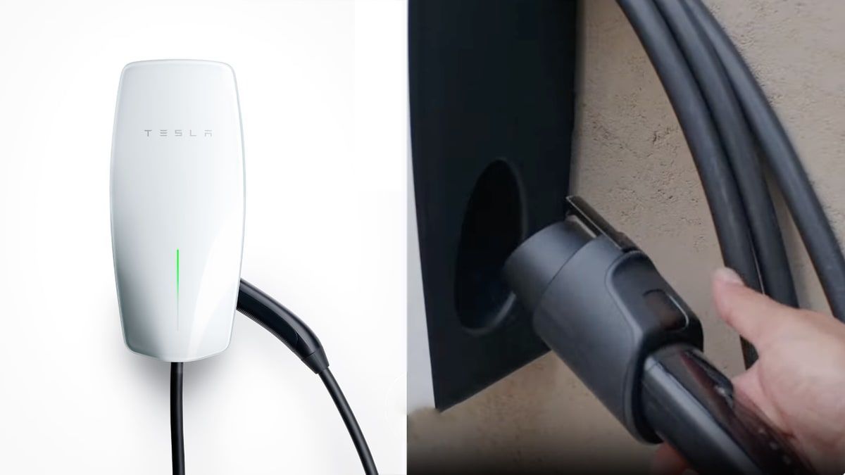 Black Tesla Wall Connector mounted on a white wall, charging cable attached.