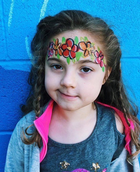 Colorful flower crown face painting on a young girl