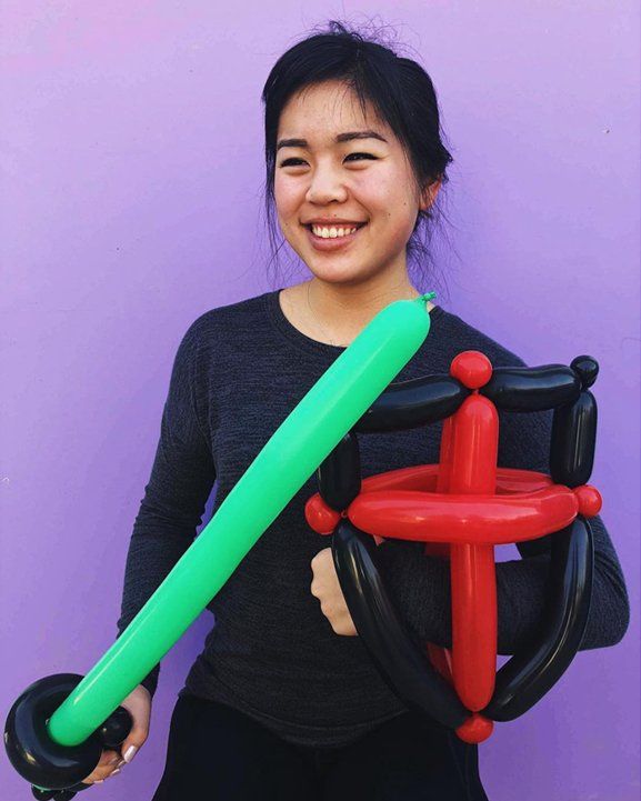 Art2Entertain artist holding a green balloon sword and a red and black balloon shield