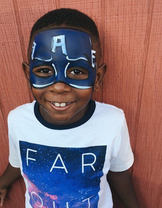 Superhero mask face painting on a smiling boy