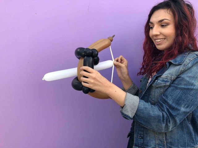 Balloon twister finishing a balloon bow and arrow