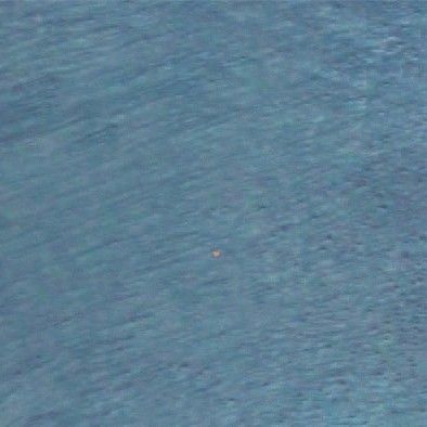 Blue rippling water with a tiny object near the center