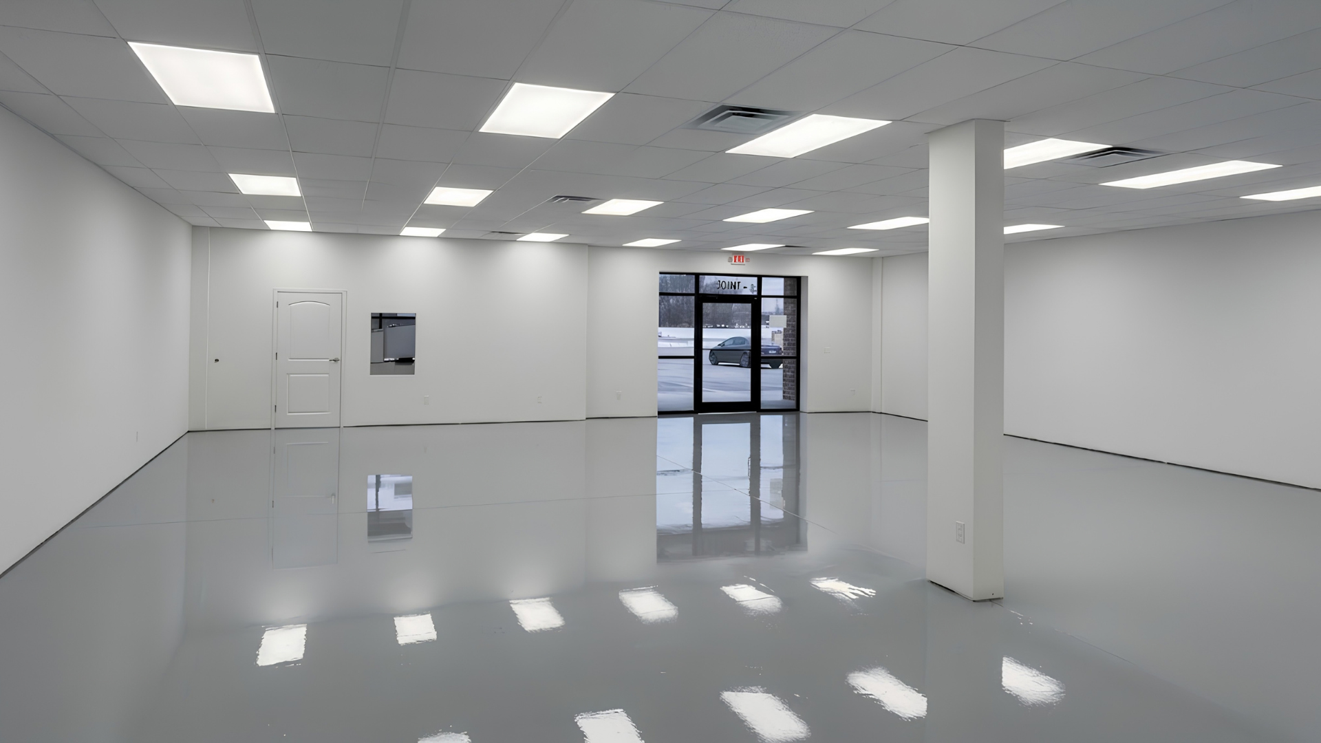 Empty white retail space with glossy floor, ceiling lights, and glass entrance doors