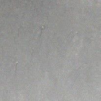 Plain gray textured surface with a small dark speck near the upper left