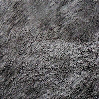 Close-up of dark gray textured stone surface with diagonal striations