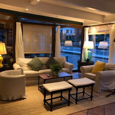 Cozy living room with cream couches, large windows, and a jute rug.