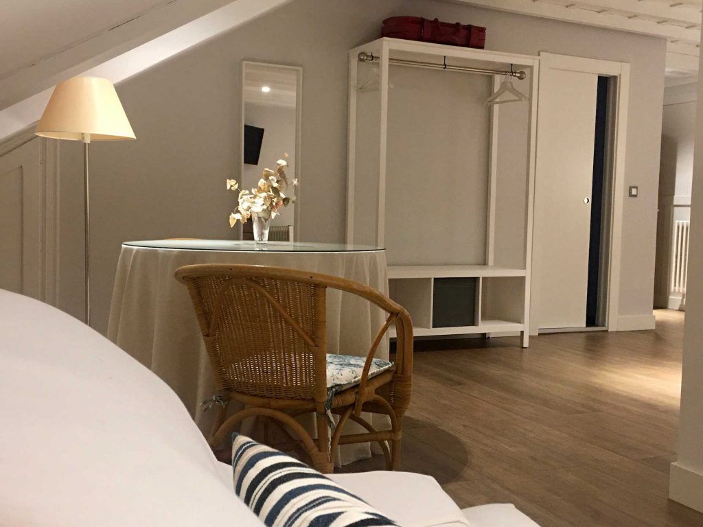 Cozy bedroom interior with a chair, table, and open closet.