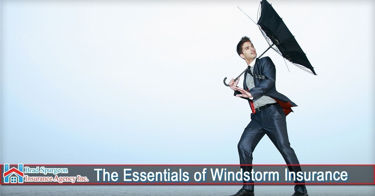 A man in a suit struggles to hold an umbrella against strong winds