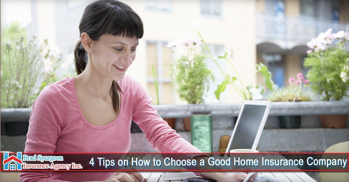 A person in a pink shirt sits on a balcony with a laptop