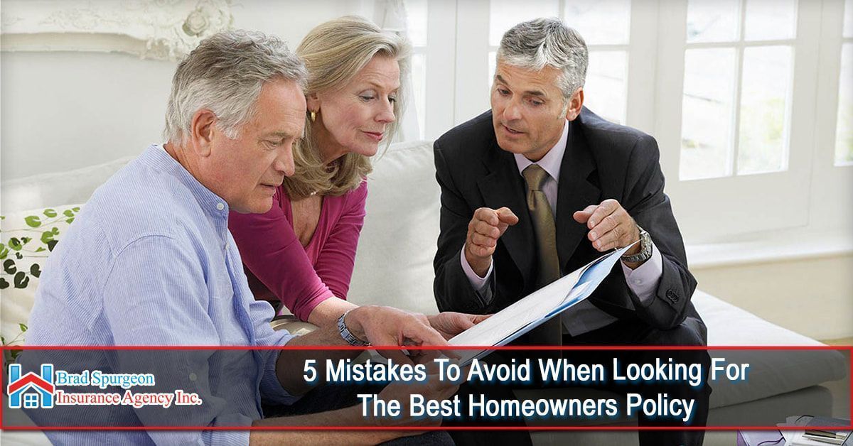 An insurance agent discusses documents with two people in a bright, indoor setting.