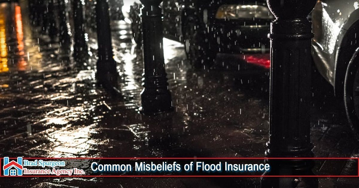 A rainy, dark street scene with parked cars 
