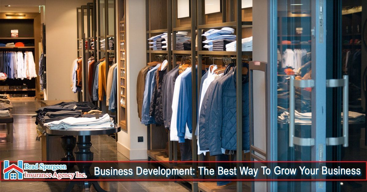 A modern clothing store interior featuring racks of organized shirts, jackets, and folded garments on shelves.