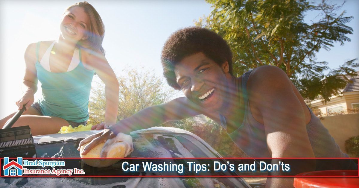 Two people wash a car on a sunny day