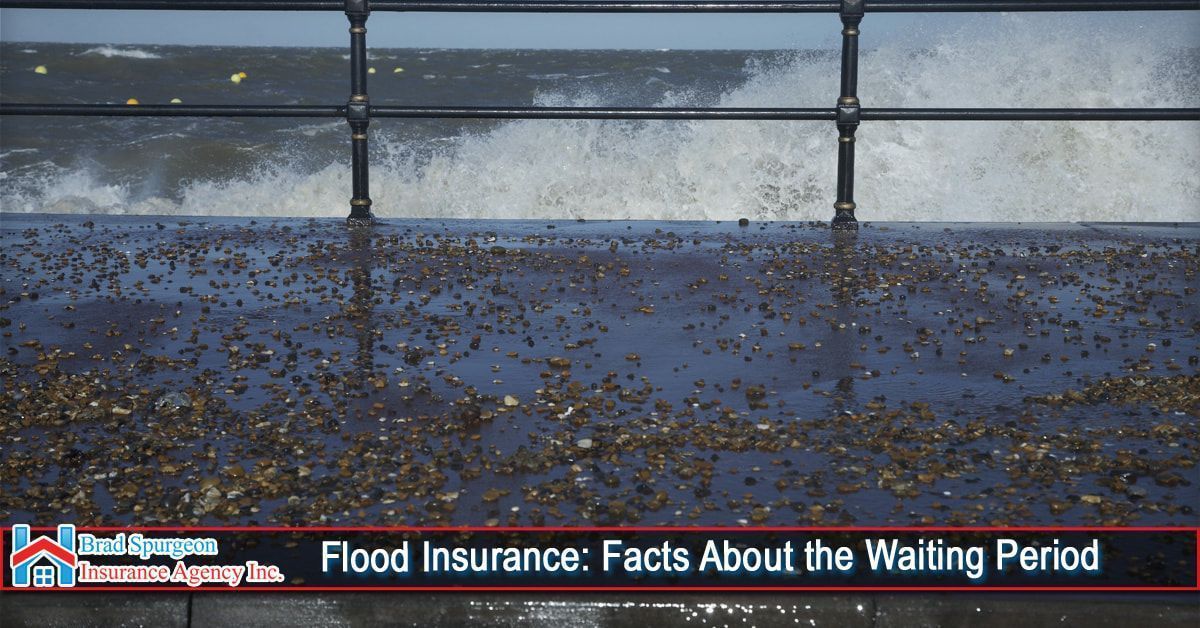 Rough sea spray hits a railing along a wet, debris-strewn walkway
