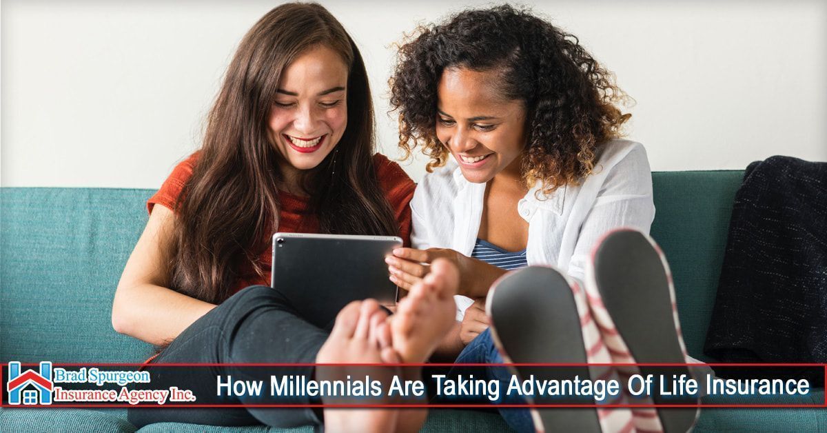 Two people sit on a couch, smiling while looking at a tablet