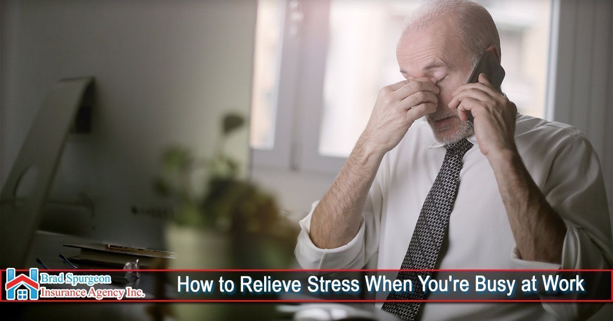 A professional at a desk, looking stressed while talking on a phone