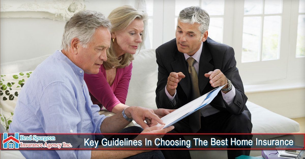 A consultant in a suit discusses paperwork with a couple in a brightly lit room.