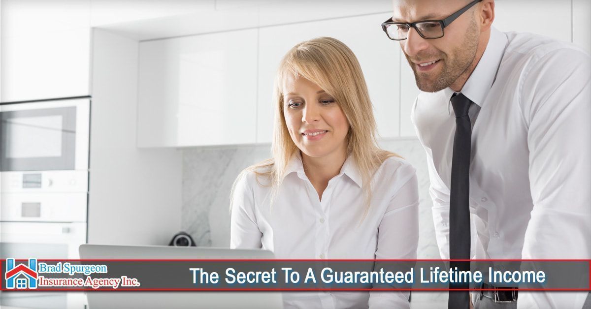 A woman and a man in business attire look at a laptop in a kitchen