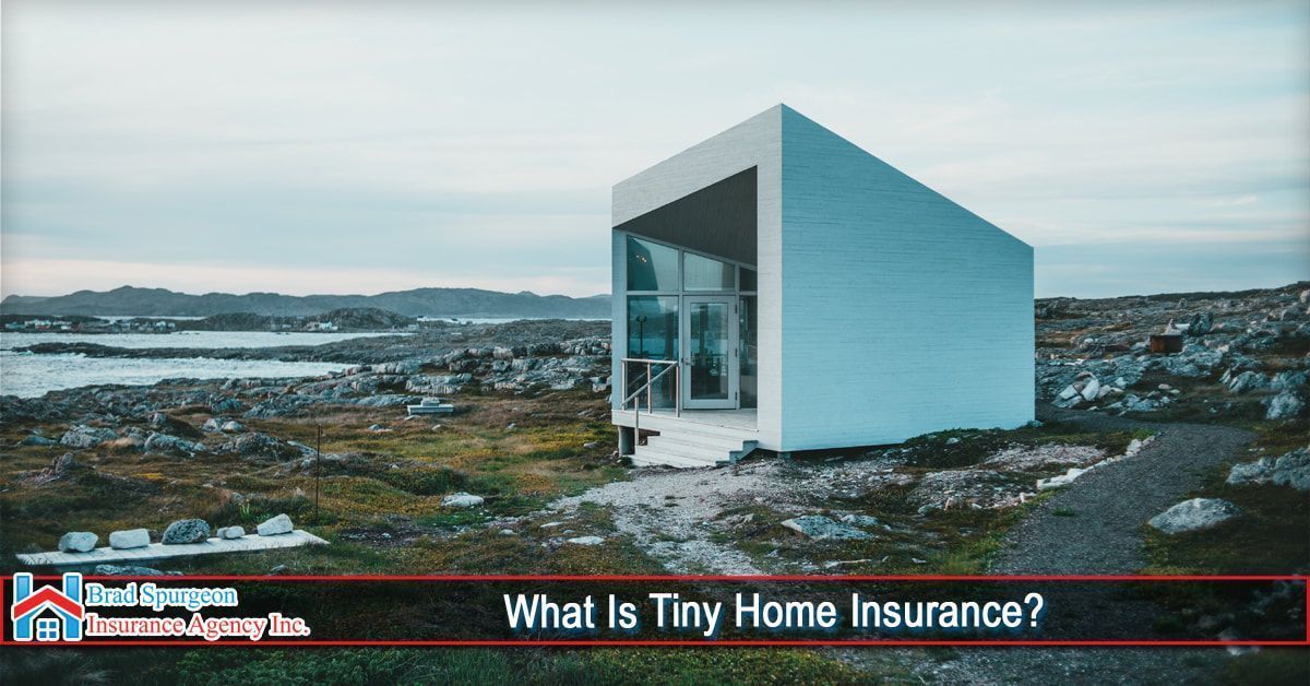 A modern, minimalist tiny home sits on a rocky, coastal landscape