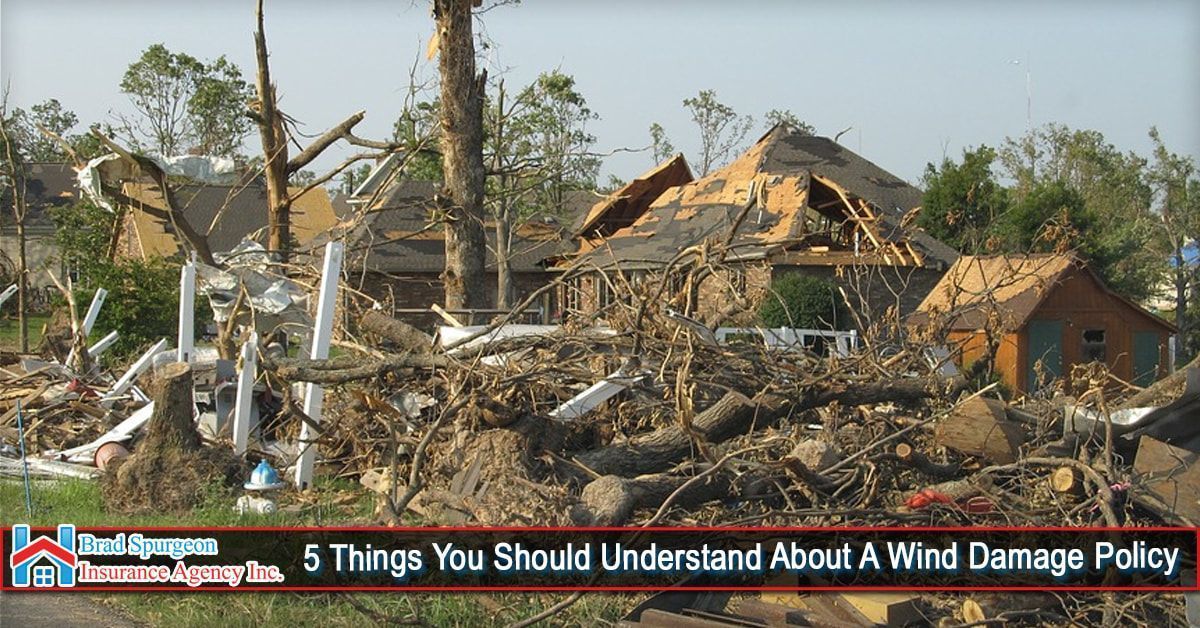 Severe wind damage to a residential neighborhood, with a house roof destroyed and debris scattered in the foreground.
