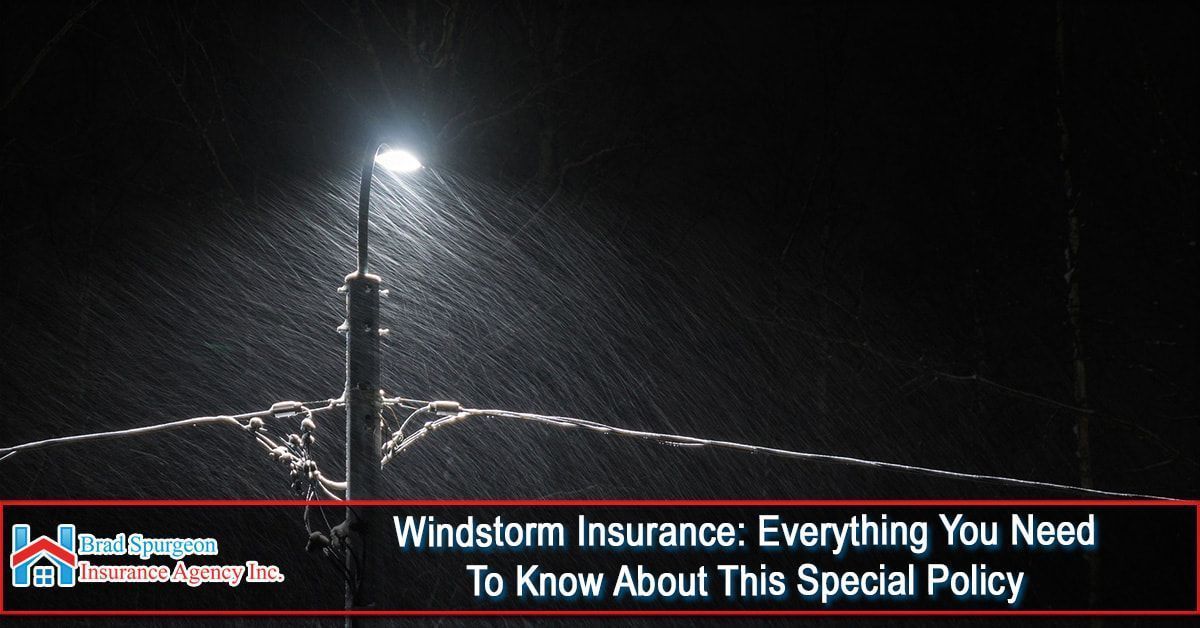 A streetlamp glows in heavy rain at night