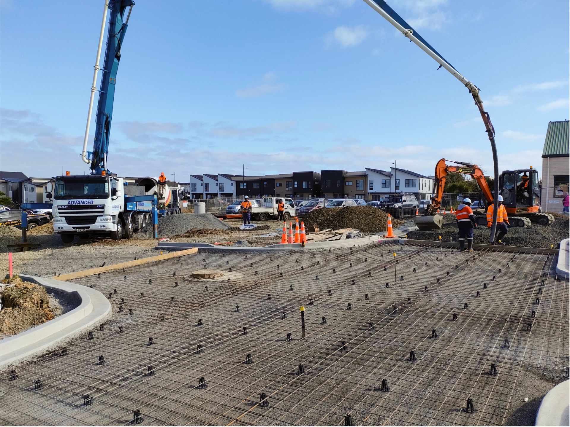 A concrete pump is being used to pour concrete on a construction site.