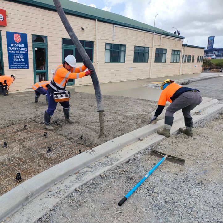 Construction workers placing a concrete footpath