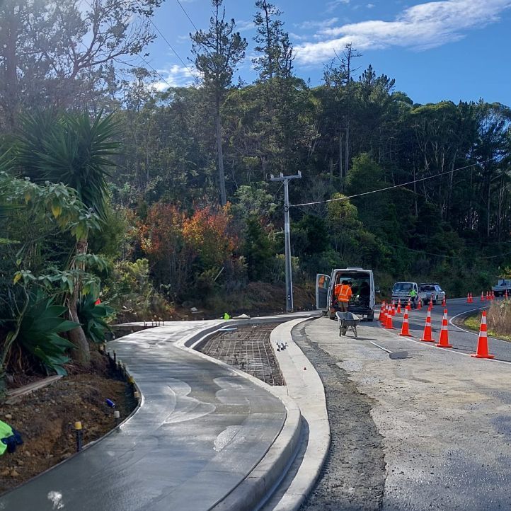A concrete walkway is being built on the side of a road