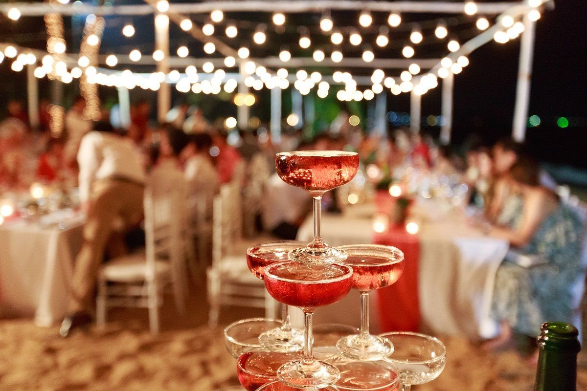 A stack of champagne glasses on a table at a wedding reception.