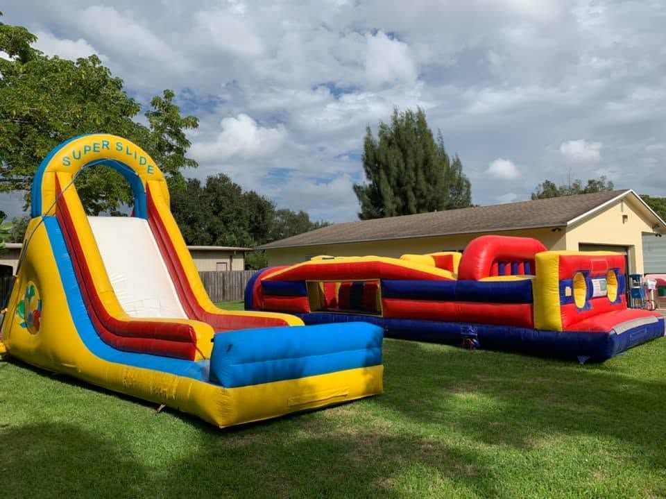 Colorful inflatable obstacle course and slide on a grassy lawn under a cloudy sky