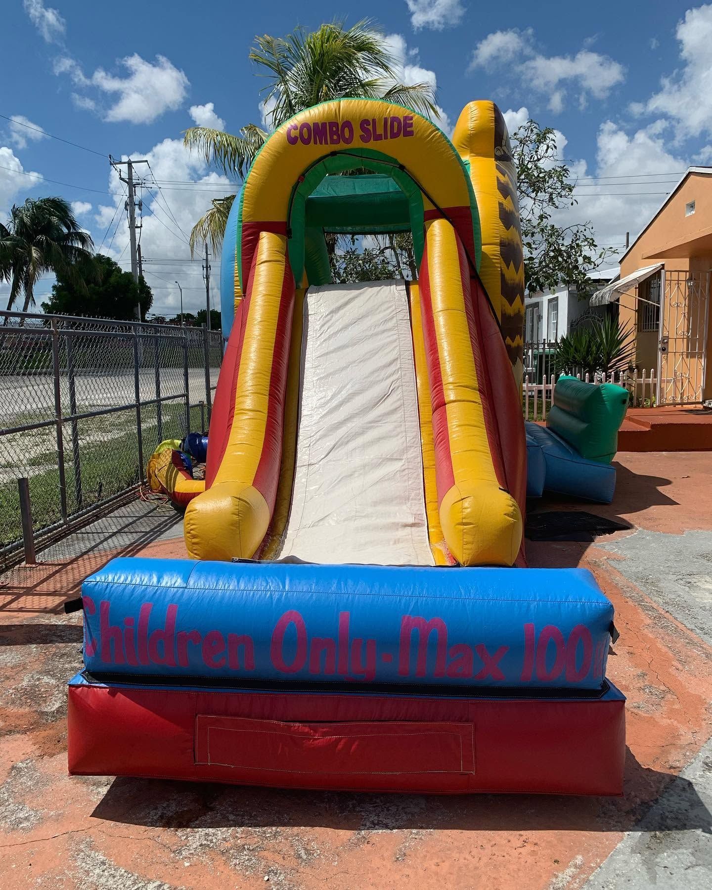 Colorful inflatable slide at an outdoor children’s party venue under a sunny sky