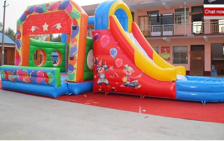 Colorful inflatable bounce house and slide setup outdoors on pavement