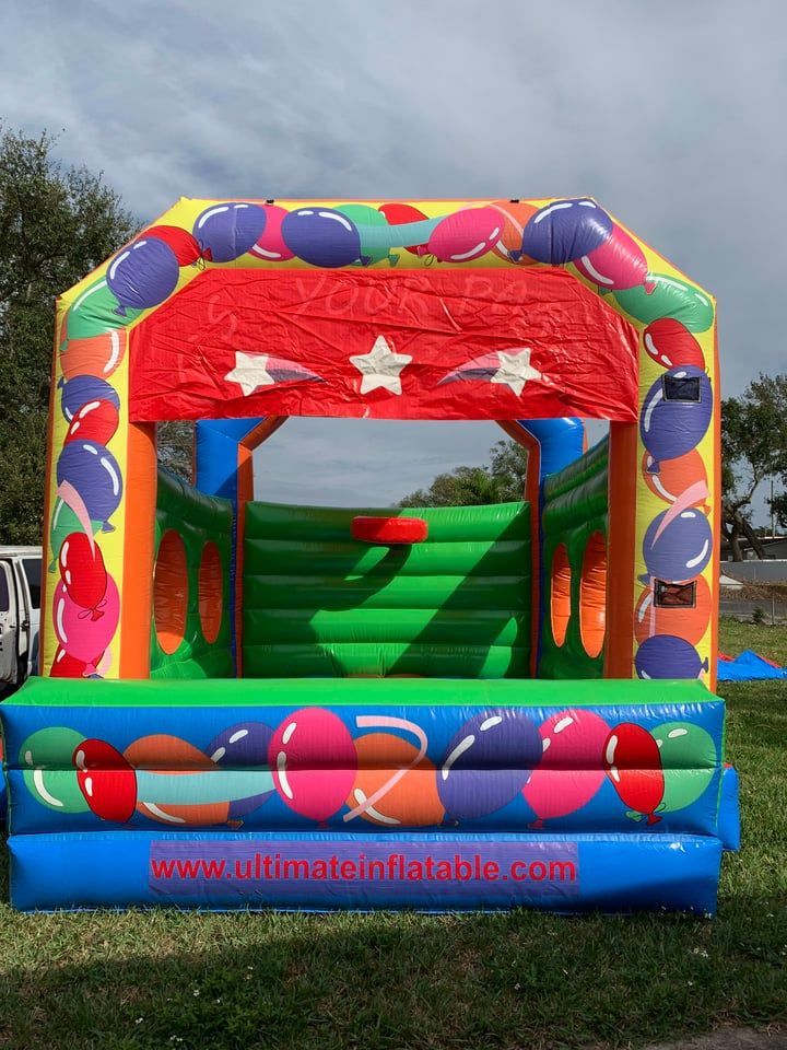 Colorful inflatable bounce house with red and green interior and a blue base outdoors