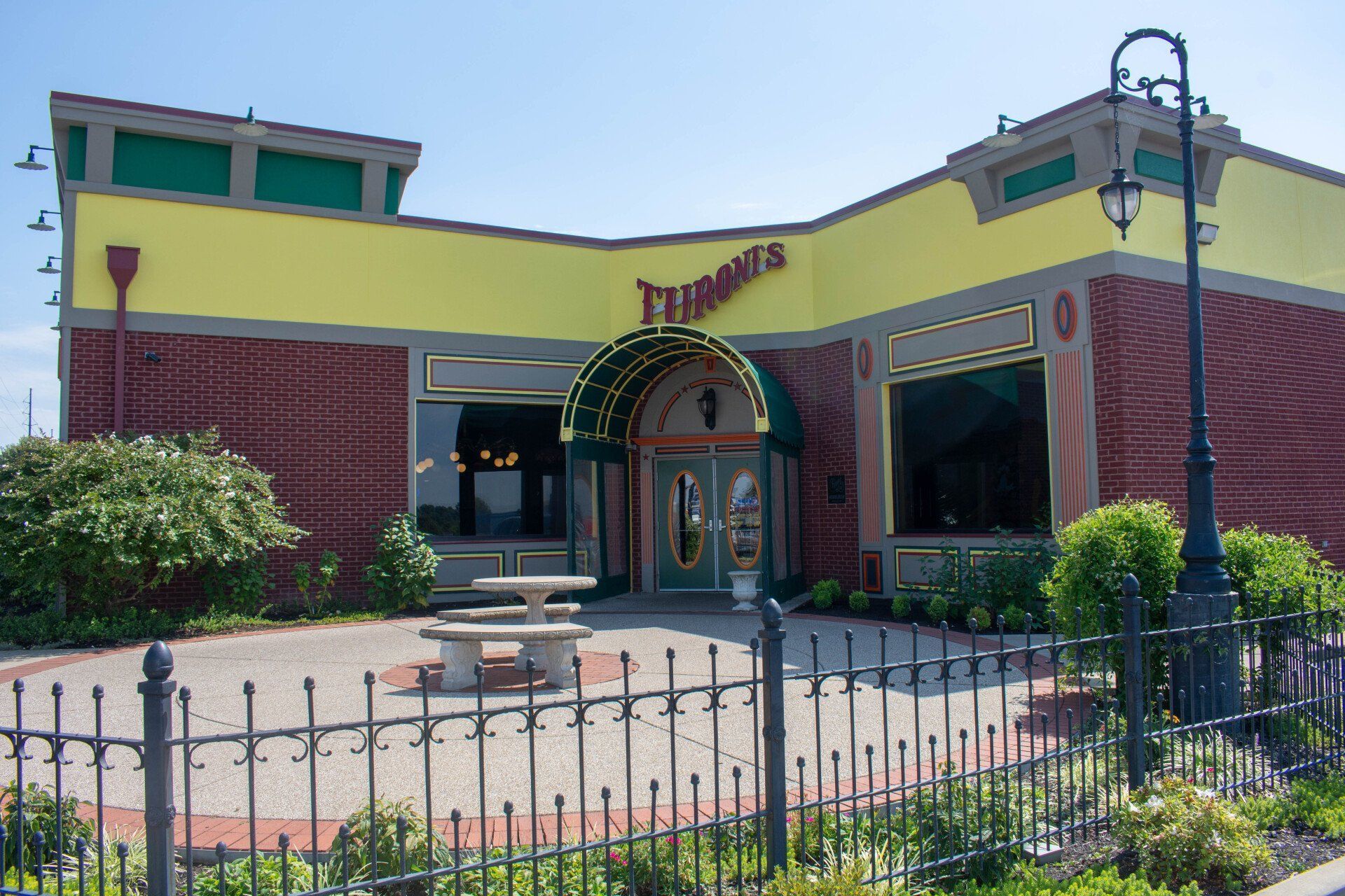 A yellow and red building with a fence in front of it