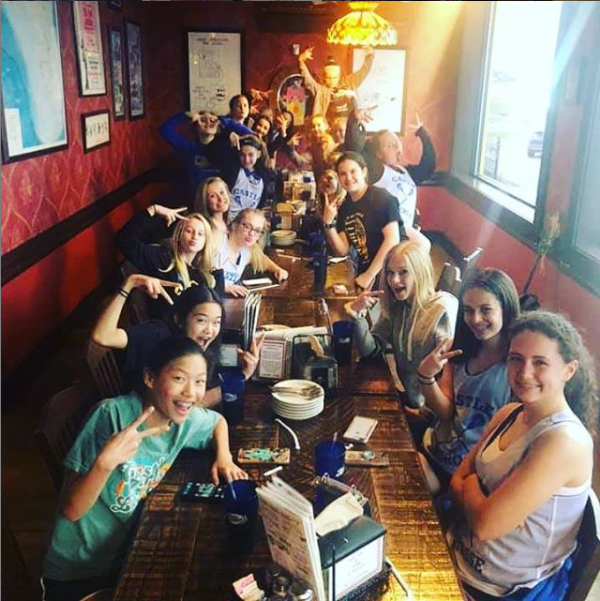 A group of people are sitting at a long table in a restaurant