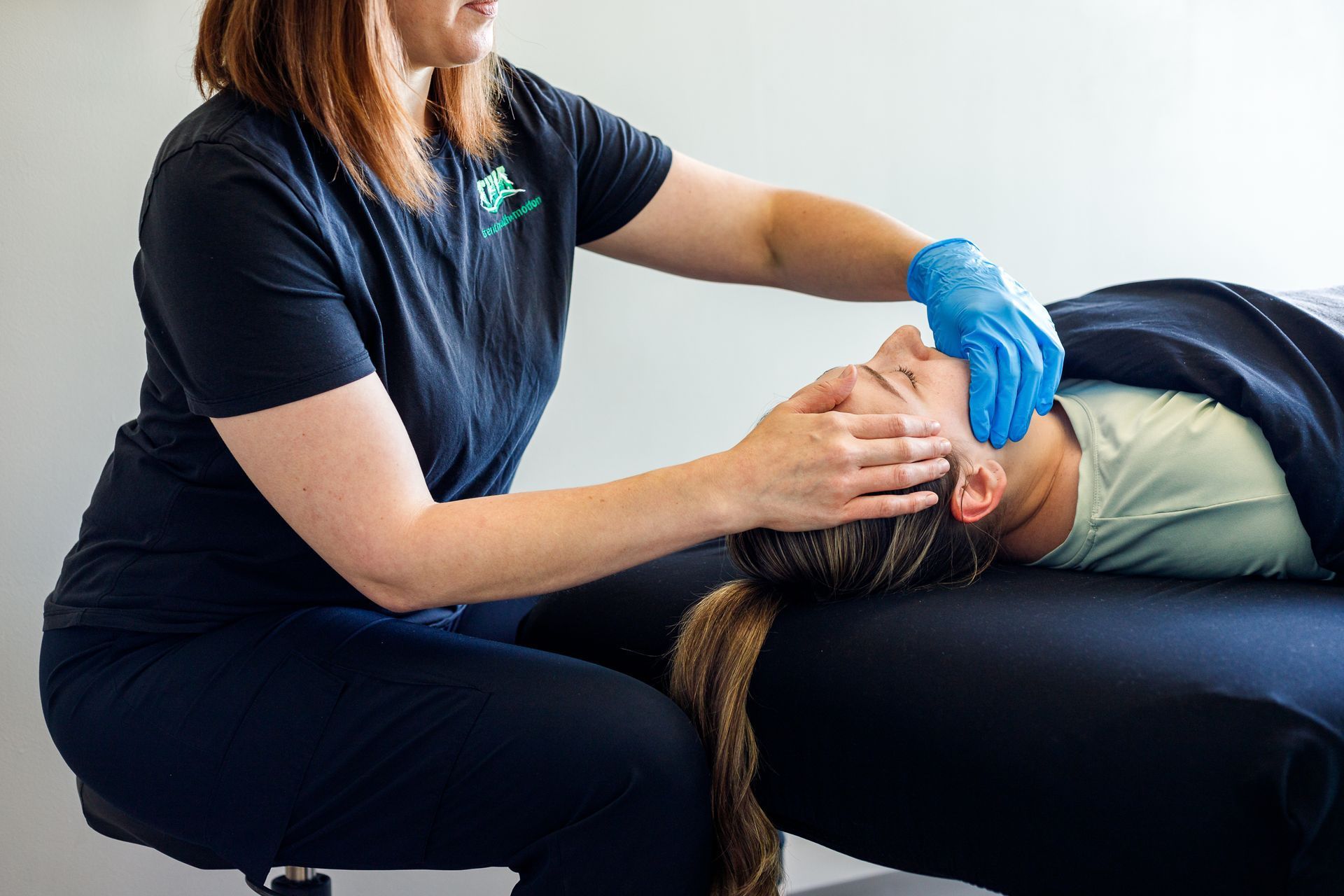 A woman is giving a man a head massage on a table.