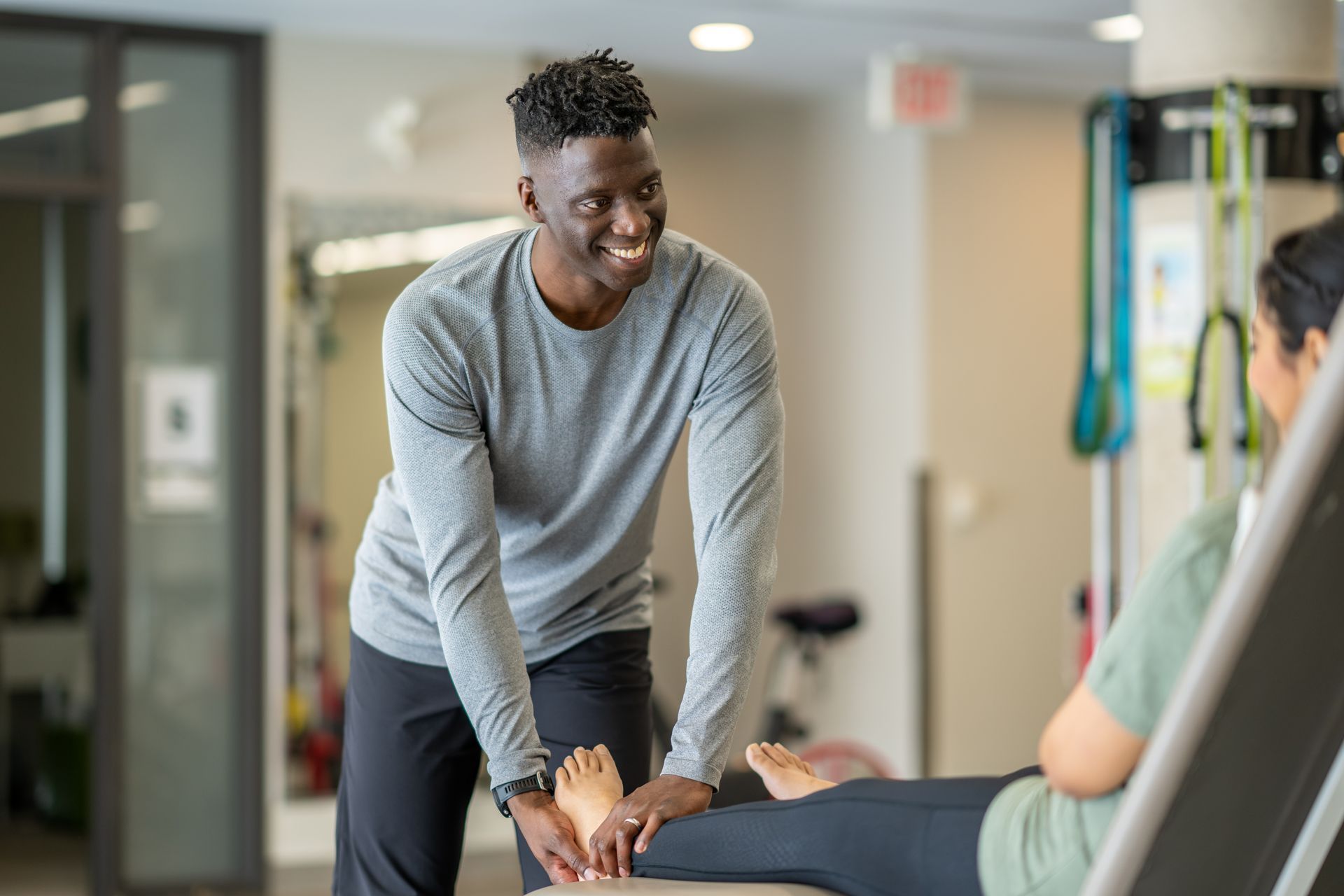 A man is stretching a woman 's leg on a table.