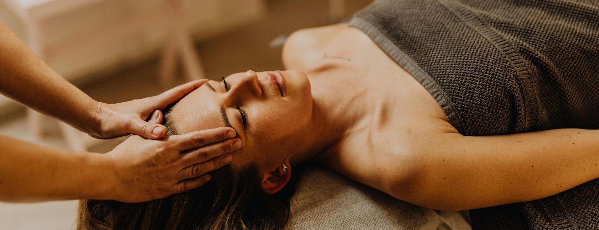 A woman is getting a head massage at a spa.