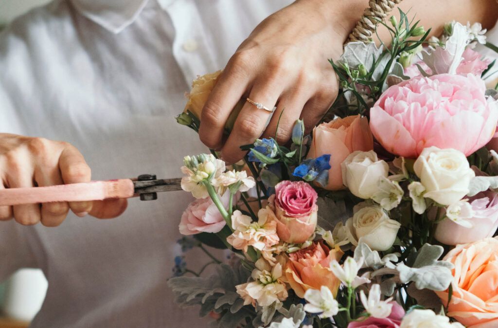 A person is making a bouquet of flowers with scissors.