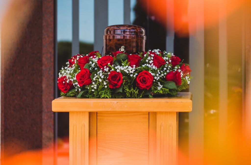 A wooden podium with red roses and baby 's breath on it.