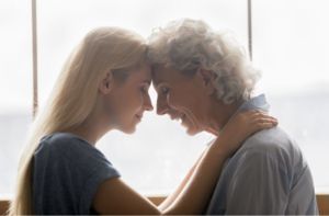 An elderly woman and a young woman are looking at each other.
